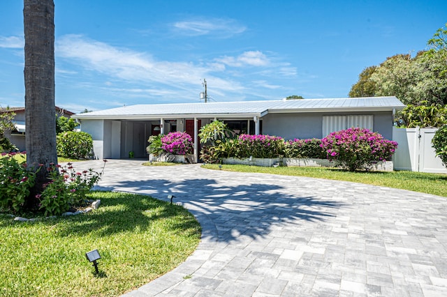 single story home featuring a front yard and a carport