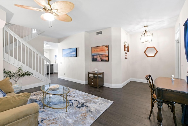 living room with dark wood-style floors, visible vents, stairway, baseboards, and ceiling fan with notable chandelier