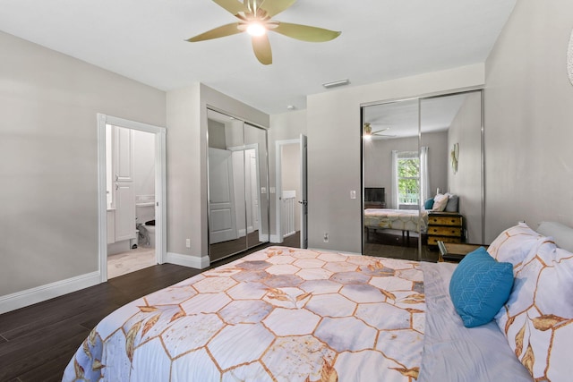 bedroom with baseboards, visible vents, a ceiling fan, dark wood-style floors, and two closets