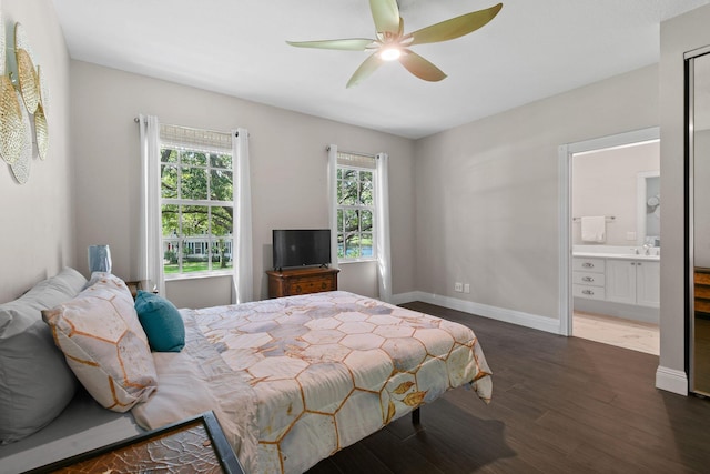 bedroom with dark wood-style floors, ceiling fan, connected bathroom, and baseboards