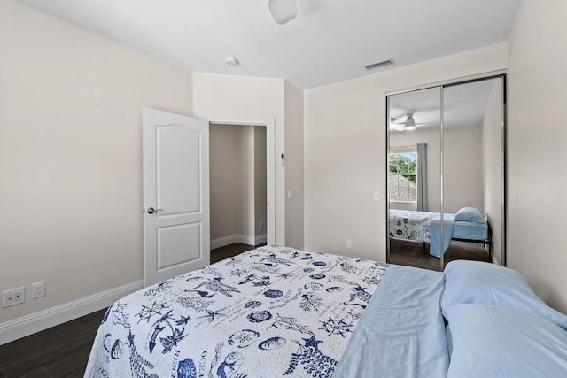 bedroom with dark wood-style floors, a closet, visible vents, and baseboards