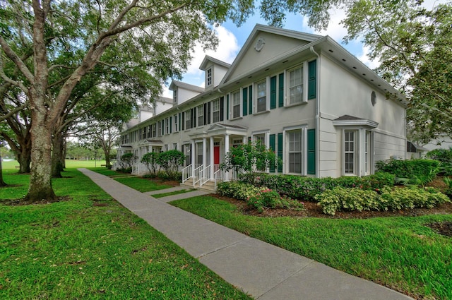 view of front of home with a front lawn and stucco siding