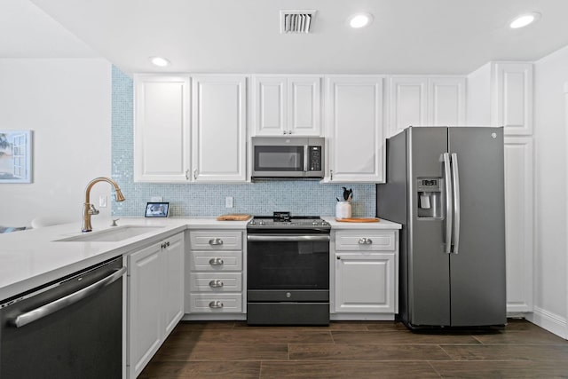 kitchen with white cabinets, stainless steel appliances, a sink, and light countertops