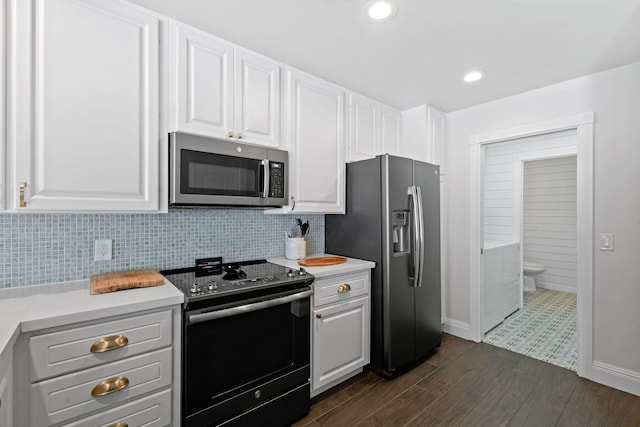 kitchen with appliances with stainless steel finishes, light countertops, backsplash, and white cabinetry