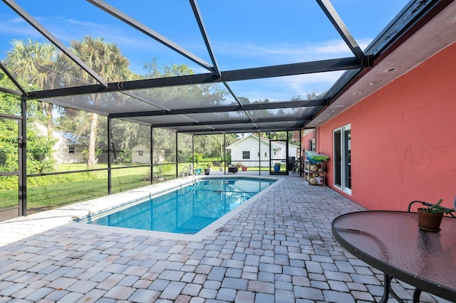 view of swimming pool with a yard, a patio area, and a lanai