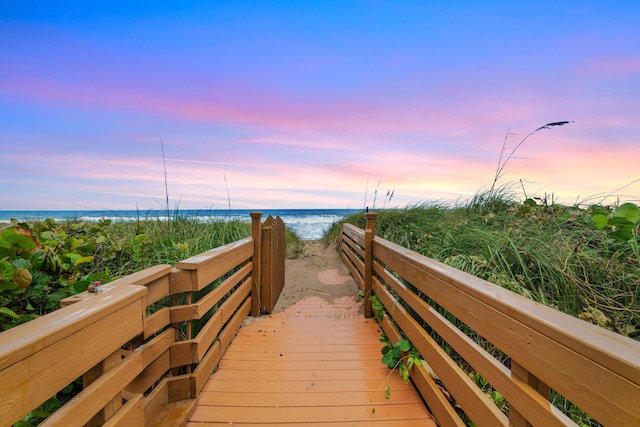 view of home's community featuring a water view and a beach view