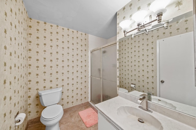 bathroom featuring tile patterned flooring, vanity, toilet, and walk in shower