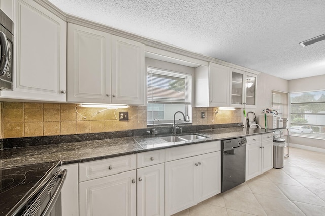 kitchen with light tile patterned flooring, black dishwasher, white cabinetry, and sink