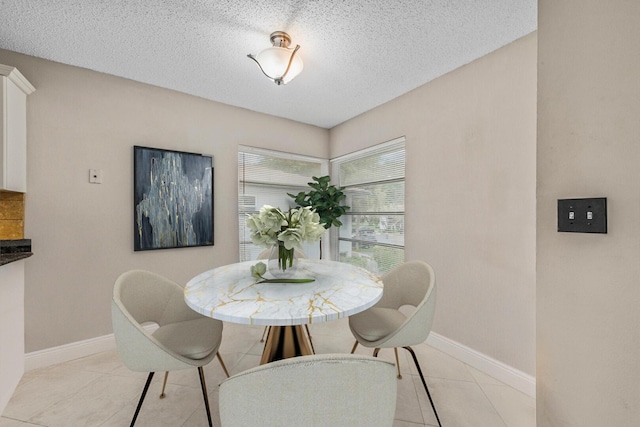 tiled dining area featuring a textured ceiling