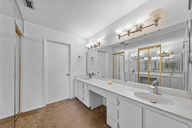 bathroom with a textured ceiling and vanity