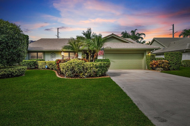 single story home featuring a yard and a garage