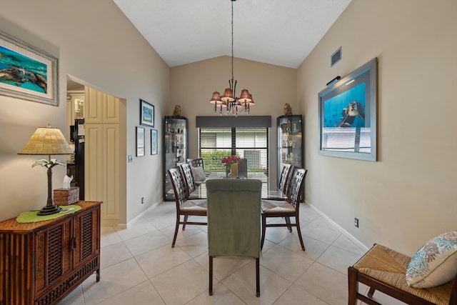 dining space with light tile patterned flooring, lofted ceiling, and a chandelier