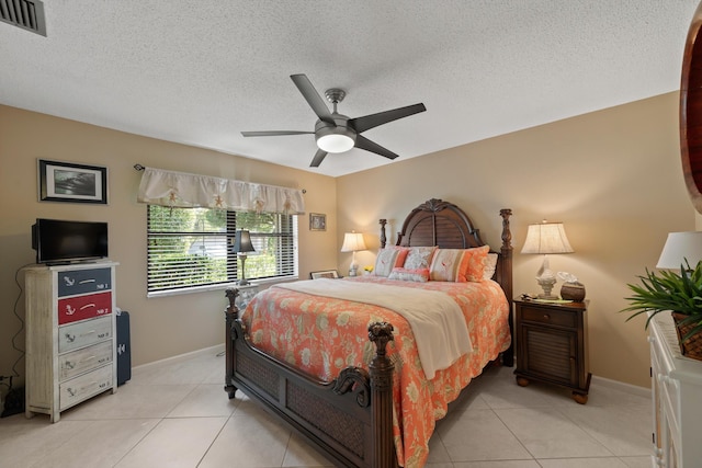 bedroom featuring ceiling fan, light tile patterned floors, and a textured ceiling