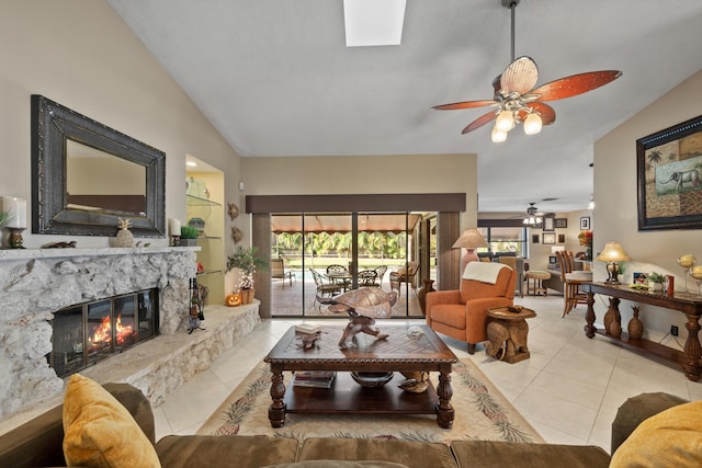 living room featuring a high end fireplace, ceiling fan, lofted ceiling, and light tile patterned flooring