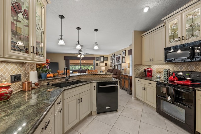 kitchen featuring cream cabinets, sink, black appliances, and hanging light fixtures