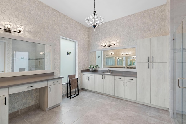 bathroom featuring vanity, an inviting chandelier, and a shower with shower door