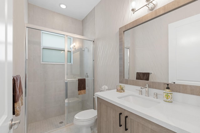 bathroom featuring vanity, an enclosed shower, and toilet