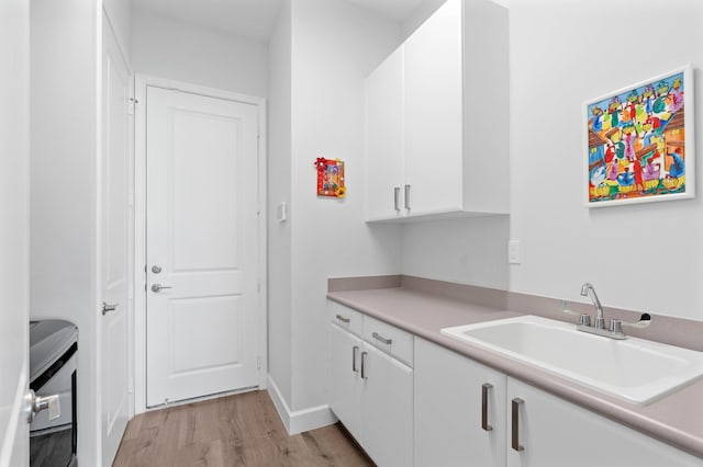 kitchen featuring white cabinets, light hardwood / wood-style flooring, and sink