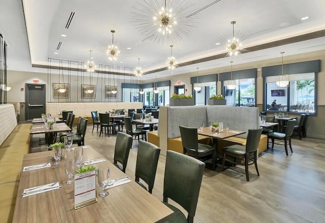 dining space with a tray ceiling and a notable chandelier