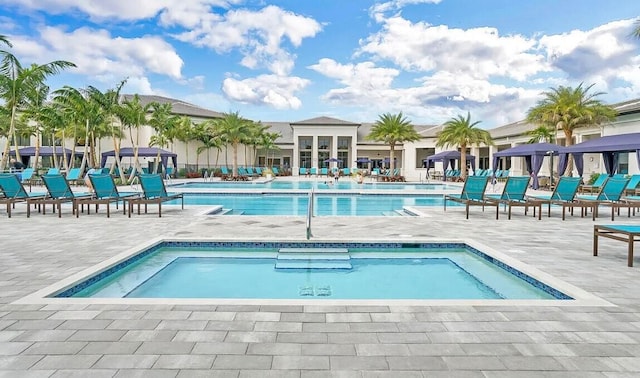 view of pool featuring a community hot tub and a patio