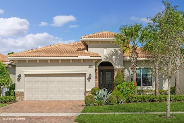 mediterranean / spanish-style house with a garage and a front yard