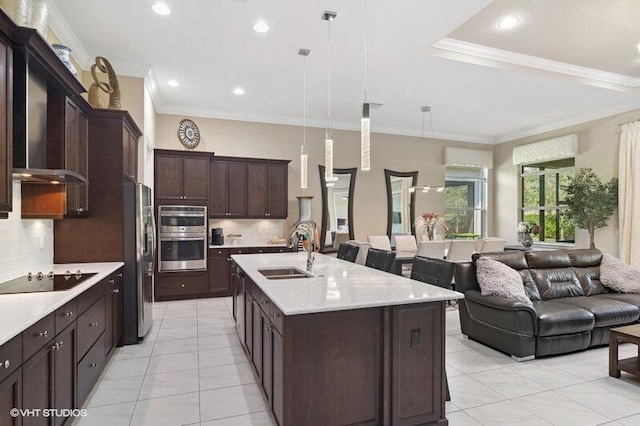 kitchen with decorative backsplash, hanging light fixtures, sink, and stainless steel appliances