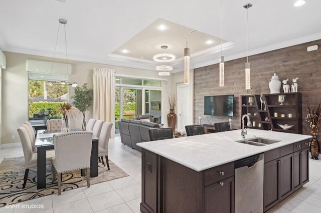 kitchen featuring stainless steel dishwasher, hanging light fixtures, sink, and a raised ceiling