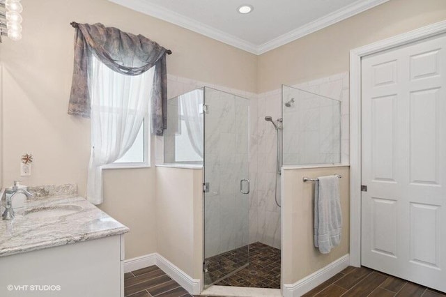 bathroom with walk in shower, hardwood / wood-style floors, vanity, and crown molding