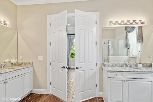 bathroom with ornamental molding, an enclosed shower, wood-type flooring, and vanity