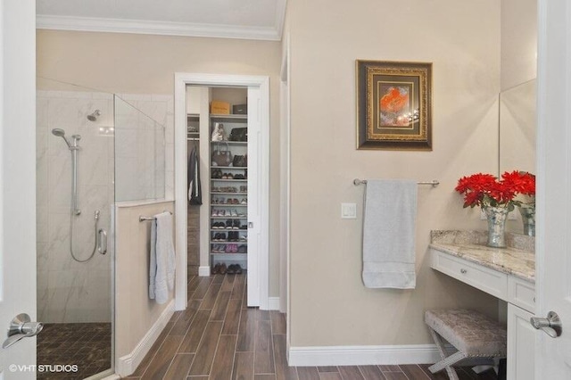 bathroom featuring vanity, crown molding, and a shower with door