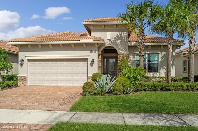 mediterranean / spanish-style home featuring a garage and a front yard