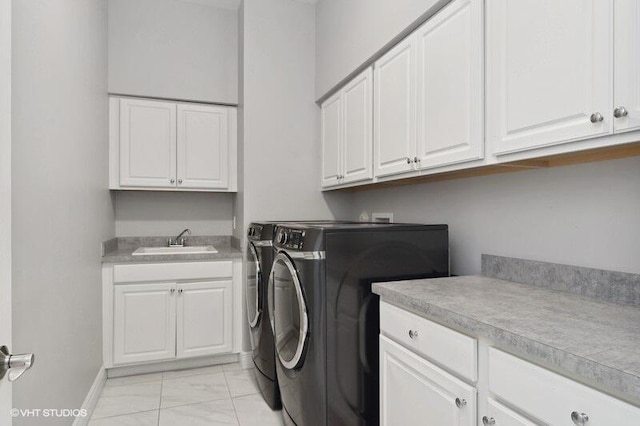 laundry area with cabinets, separate washer and dryer, and sink