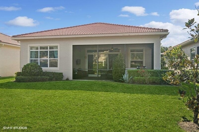 rear view of house with a sunroom and a yard