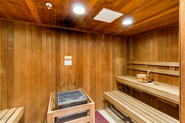 view of sauna with wood ceiling and wooden walls