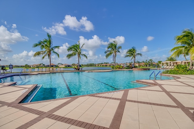 view of pool with a patio and a water view