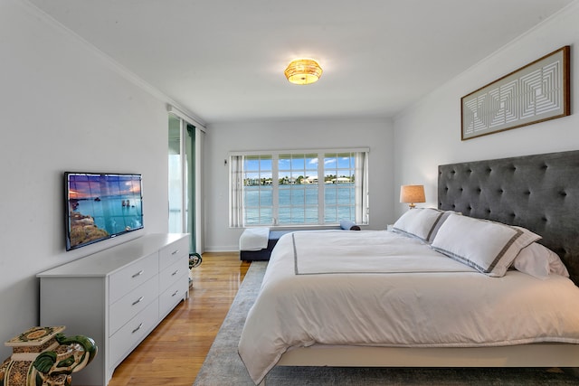 bedroom with ornamental molding and light wood-type flooring