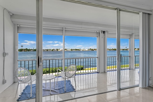 doorway to outside with a water view and light tile patterned floors