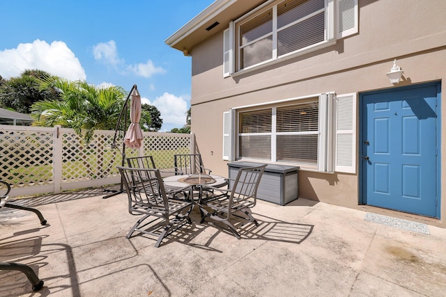 view of patio featuring outdoor dining area and fence