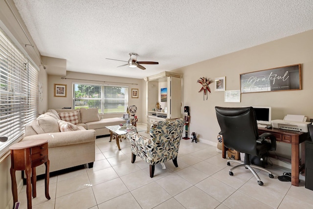 interior space featuring ceiling fan, a textured ceiling, light tile patterned flooring, and baseboards