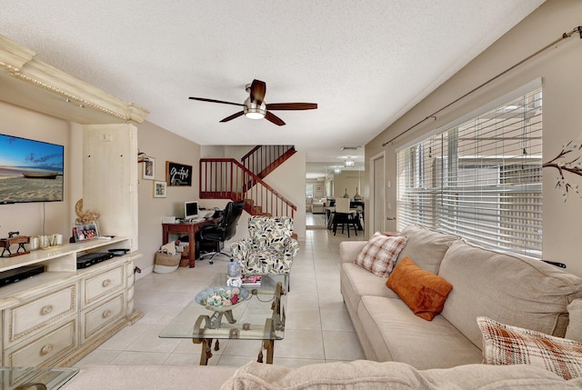 living room featuring a ceiling fan, stairway, a textured ceiling, and light tile patterned floors