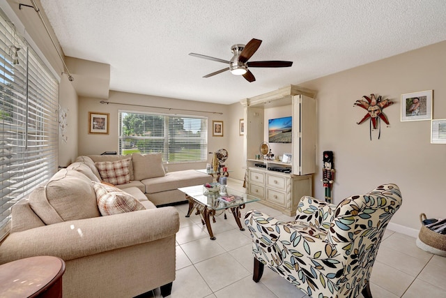 living room featuring light tile patterned floors, a textured ceiling, a ceiling fan, and baseboards