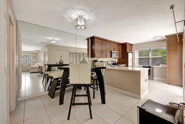 dining area featuring light tile patterned floors and a textured ceiling