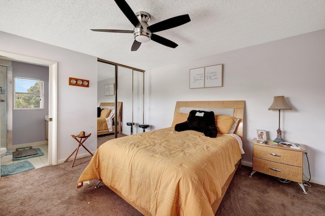 bedroom with a textured ceiling, a ceiling fan, baseboards, a closet, and dark carpet