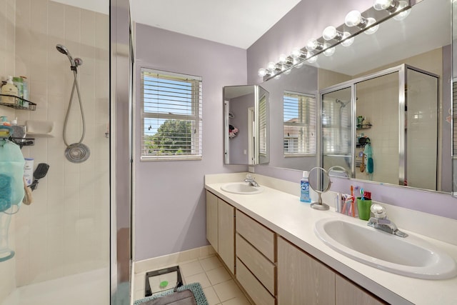 bathroom featuring a stall shower, a sink, a wealth of natural light, and tile patterned floors