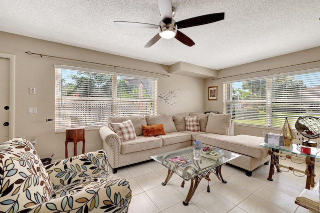 tiled living room with ceiling fan and a textured ceiling