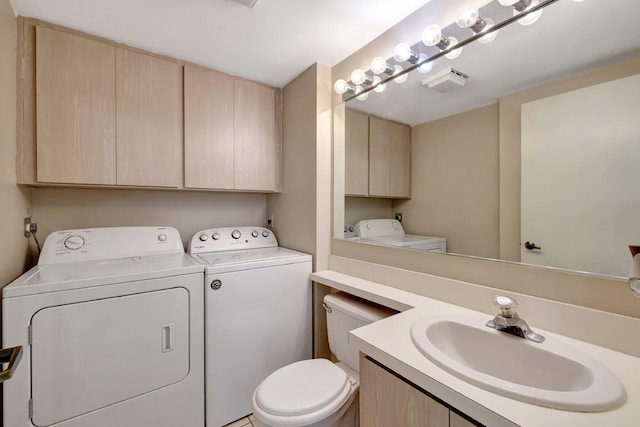 half bathroom with visible vents, vanity, washing machine and dryer, and toilet