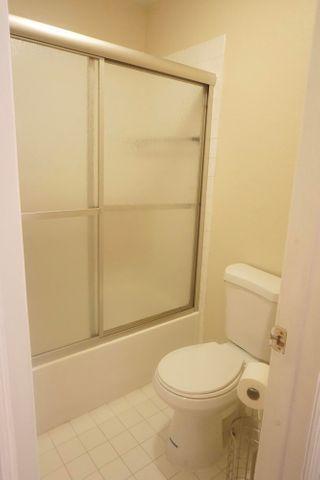 bathroom featuring toilet, tile patterned flooring, and enclosed tub / shower combo