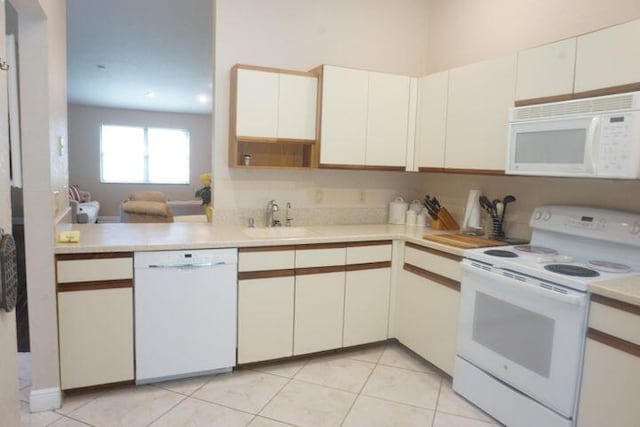 kitchen with white appliances, light tile patterned floors, sink, white cabinets, and kitchen peninsula