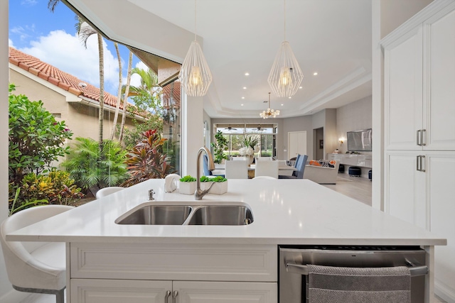 kitchen with sink, decorative light fixtures, and white cabinets