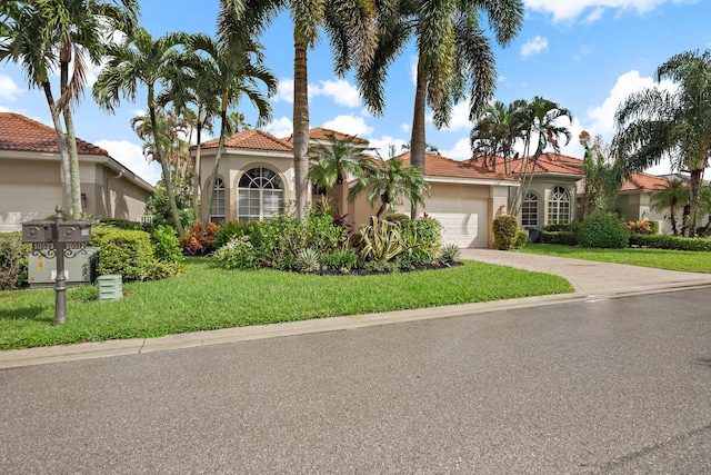 mediterranean / spanish house featuring a front yard and a garage